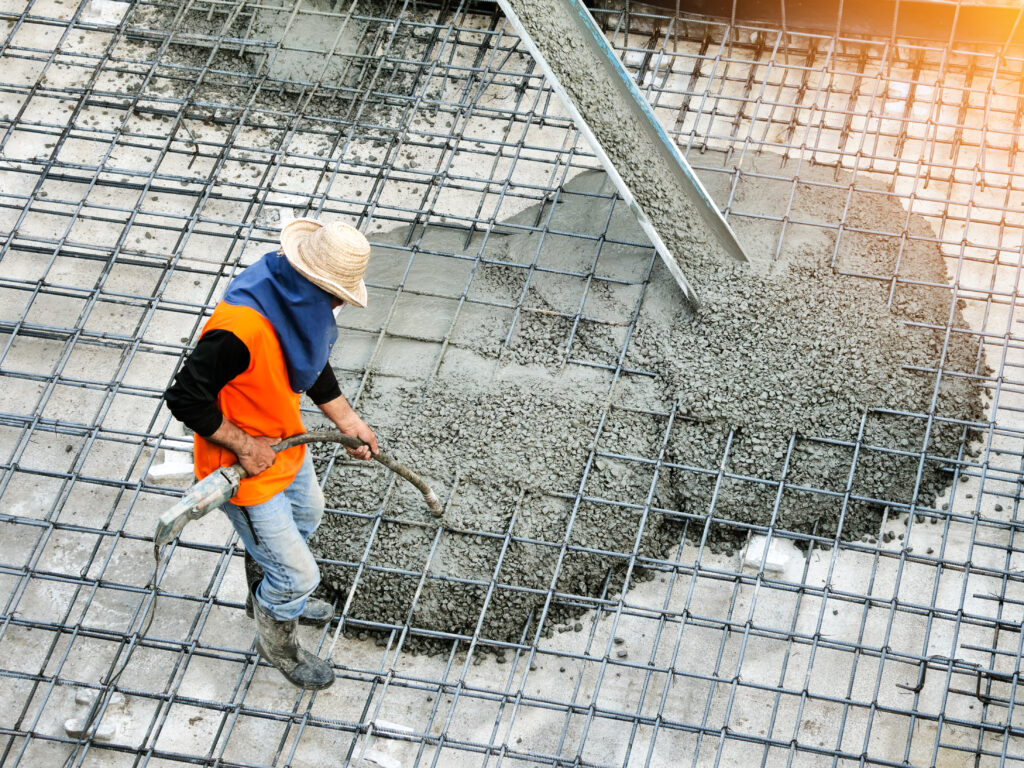 top view of builders in orange shirt pouring concrete works on t